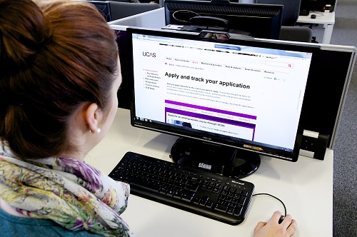 Prospective student using a computer to check their application for University.